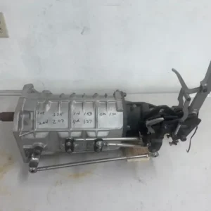 Doug Nash 5 Speed Transmission, Buy Doug Nash 5 Speed Transmission, Doug Nash racing gearbox, Nash competition manual, vintage drag racing gearbox, classic race five speed, old school racing manual, heritage drag transmission, American race gearbox, period correct racing transmission, vintage performance gearbox, classic competition driveline, pro shift manual gearbox, pro shifted racing manual, face plated race gearbox, crash box racing manual, competition engagement gearbox, drag shift transmission, clutch assisted race gearbox, full throttle manual shifting, racing manual gear engagement, modified manual transmission, Long vertical gate shifter, Long Engineering shifter, pistol grip race shifter, vertical gate racing shifter, drag car V gate, five position race shifter, competition shifter linkage, racing linkage rods, drag manual shifter, vintage Long shifter, 3.25 first gear transmission, 2.07 second gear gearbox, 1.53 third gear transmission, 1.27 fourth gear gearbox, direct fifth manual gearbox, close ratio racing five speed, deep first gear race transmission, direct top gear gearbox, non overdrive five speed, race transmission ratio spread, Chevy drag car gearbox, Chevrolet race manual, Chevy muscle car gearbox, Chevrolet competition driveline, small block Chevy manual gearbox, big block Chevy manual gearbox, Camaro race transmission, Chevelle drag gearbox, Nova racing transmission, Corvette competition gearbox, classic Chevy five speed, Chevy hot rod transmission, Chevrolet stick shift racing, Chevy manual conversion gearbox, GM performance manual transmission, Mopar spline race input, 18 spline racing input, Chrysler spline clutch input, racing input shaft conversion, clutch disc spline matching, competition input shaft, manual gearbox pilot fitment, racing clutch hub spline, performance clutch compatibility, race input shaft measurement, 727 spline output gearbox, Chrysler automatic style output, 727 output shaft setup, race transmission output spline, driveshaft yoke selection, performance output yoke, custom driveshaft yoke, racing slip yoke setup, drag car driveshaft connection, competition output shaft, direct drive drag transmission, one to one top gear, rear axle gearing manual car, final drive calculation racing, drag car overall ratio, manual transmission launch ratio, tire size gearing calculator, race car RPM calculator, differential ratio planning, acceleration gearing setup, quarter mile manual gearing, drag race rear gear selection, manual race car powerband, gear drop RPM calculation, shift recovery RPM, race engine gearing strategy, high RPM manual transmission, naturally aspirated drag gearbox, big block drag transmission, small block racing gearbox, high torque manual gearbox, stick shift drag car parts, clutch car race transmission, manual drag racing setup, bracket racing manual gearbox, modified eliminator transmission, vintage sportsman racing gearbox, shelf stored transmission inspection, stored gearbox service, manual transmission recommissioning, old gearbox seal inspection, race gearbox bearing check, transmission lubricant replacement, shift fork inspection manual, racing gear inspection, used manual gearbox evaluation, competition transmission servicing, vintage gearbox restoration, racing transmission maintenance, manual gearbox leak inspection, race transmission teardown, clutch alignment race car, bellhousing alignment manual, pilot bearing setup racing, transmission crossmember fabrication, shifter tunnel clearance, manual swap driveshaft length, race gearbox installation, performance transmission mounting, driveline angle setup, custom manual conversion, racing clutch installation, manual transmission fitment, drag car bellhousing setup, flywheel clutch compatibility, race gearbox parts supplier, vintage transmission dealer, used racing manual seller, competition gearbox marketplace, classic drag parts retailer, performance manual supplier, old school racing parts store, specialist gearbox dealer, drag racing drivetrain supplier, vintage motorsport parts dealer, five speed racing gearbox sale, pro shifted transmission sale, vertical gate gearbox sale, Chevy race manual for sale, used competition transmission sale, vintage drag gearbox sale, classic five speed transmission sale, performance gearbox purchase, racing manual transmission dealer, stick shift race parts, transmission pallet delivery, racing gearbox freight, manual transmission shipping, competition driveline transport, vintage gearbox delivery, nationwide transmission logistics, international gearbox freight, heavy drivetrain shipping, race parts crate service, performance transmission transport, TorqueLine vintage transmissions, TorqueLine manual gearboxes, TorqueLine drag drivetrains, TorqueLine Chevy transmissions, TorqueLine competition manuals, TorqueLine racing gearboxes, TorqueLine used gearboxes, TorqueLine stick shift parts, TorqueLine transmission shipping, TorqueLine drivetrain sales